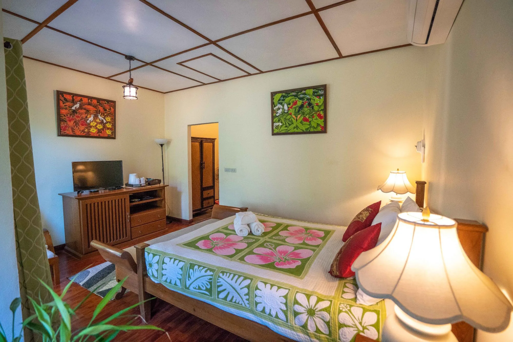 Air Nest deluxe room with bed, teak furniture, television and lamp