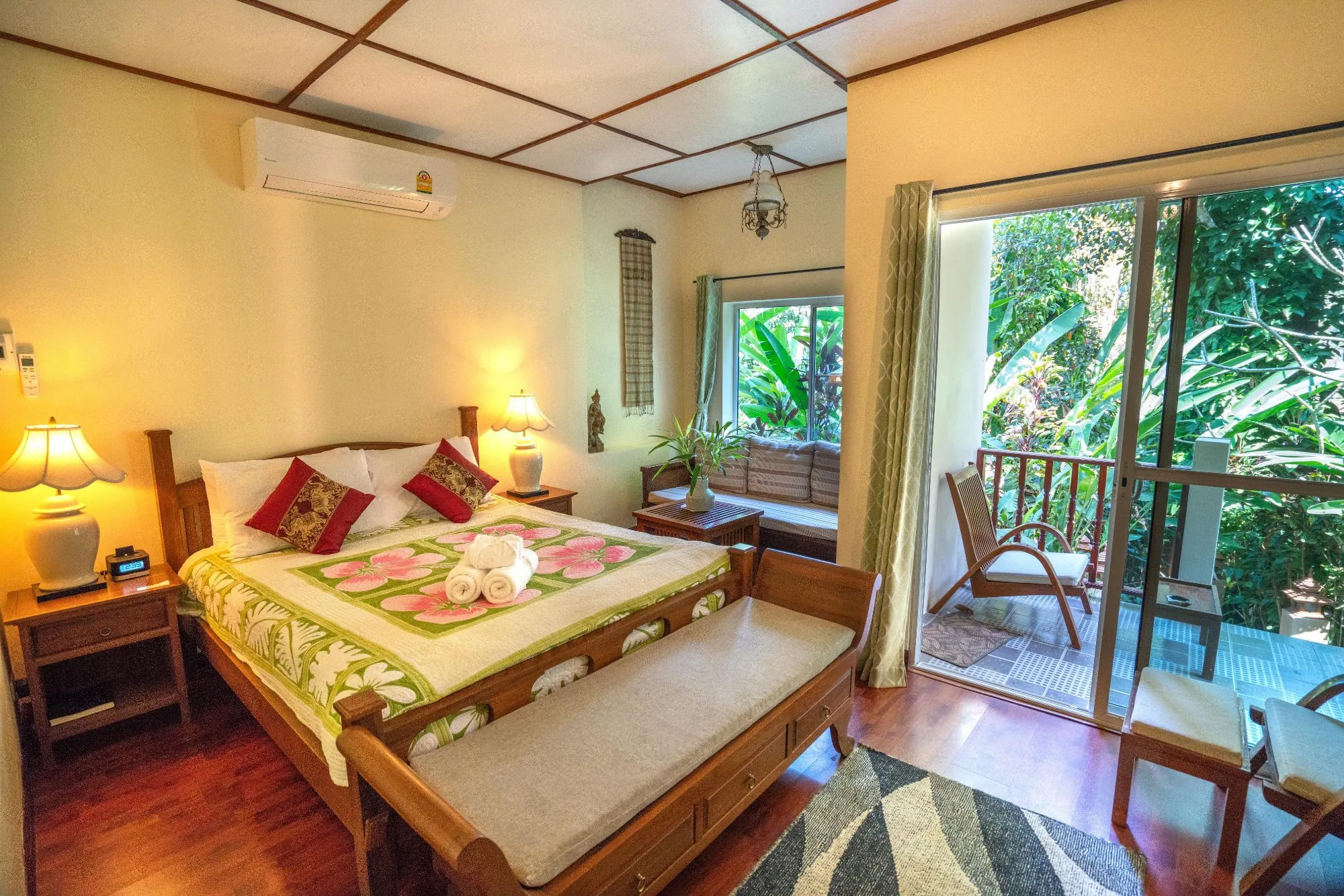 Ground Nest deluxe room with teak bed, sitting bench and garden balcony at Aerie Lodge