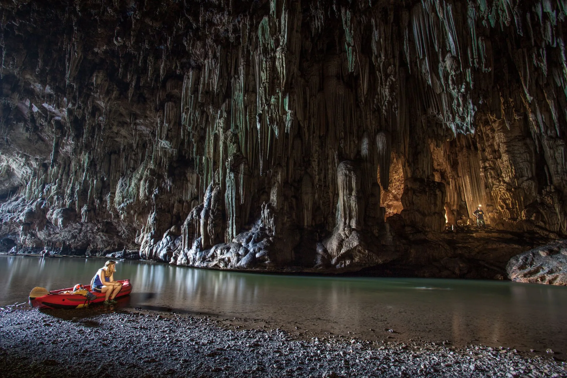 Kayak pulled up on the shore of the river inside Tham Lod cave