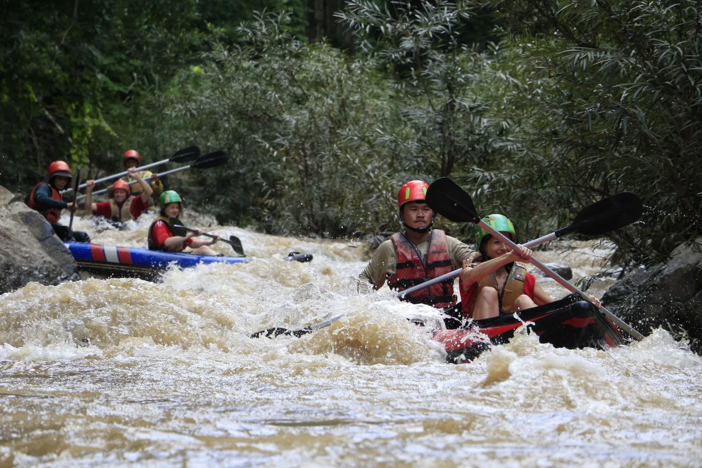 Guests paddling through white water on the river near Soppong